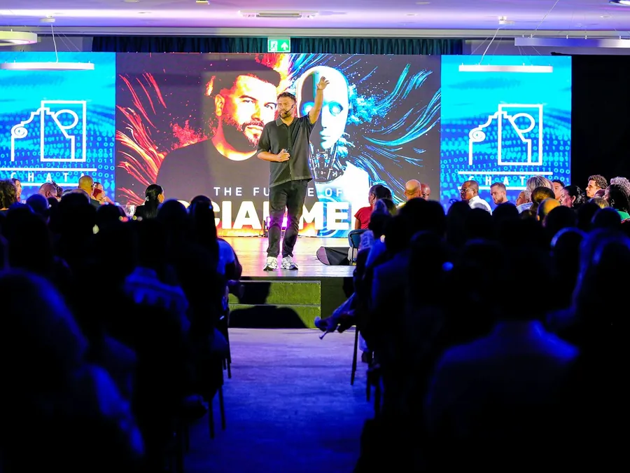 Plateia assistindo a uma apresentação em palco durante um evento corporativo
